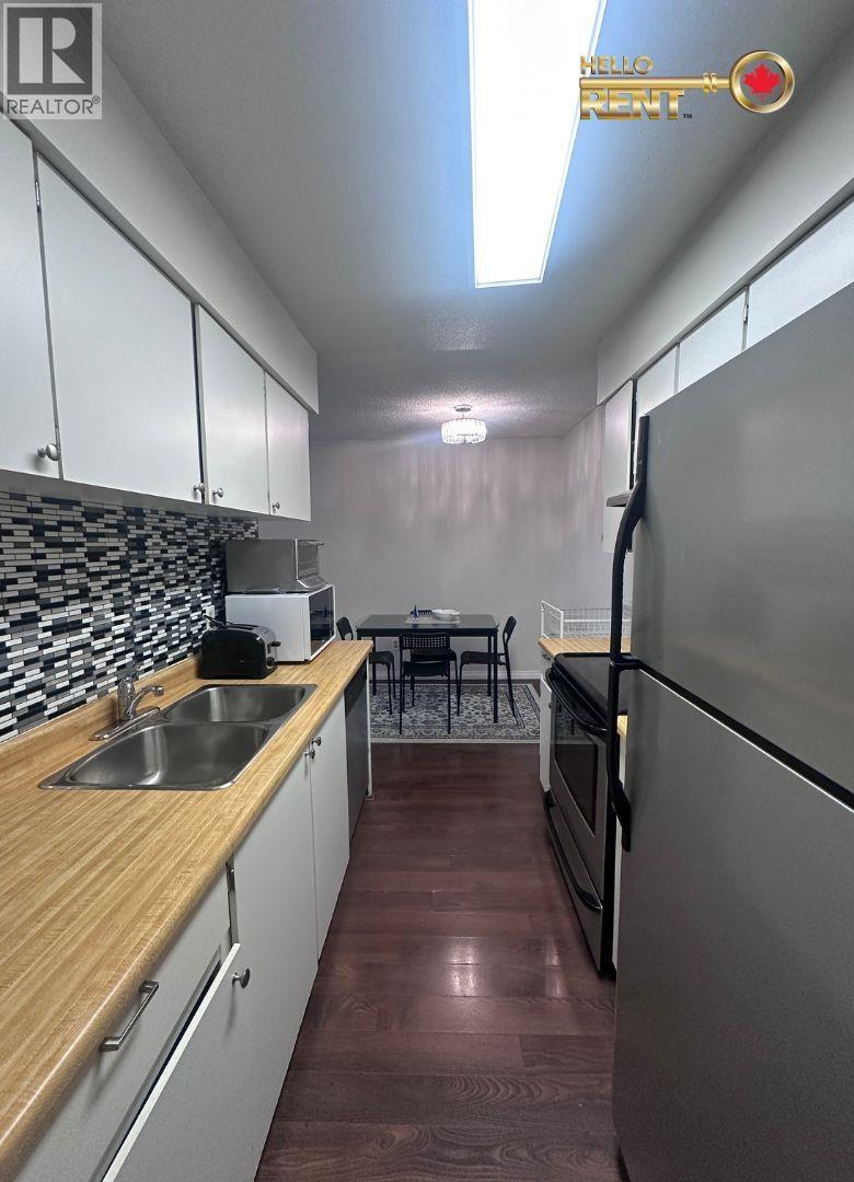 A kitchen with a wooden counter top and stainless steel appliances.