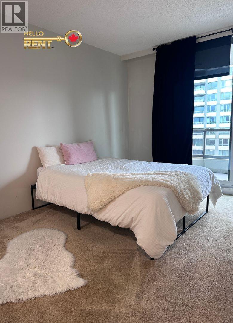 A bedroom with a white bed and a white furry rug.