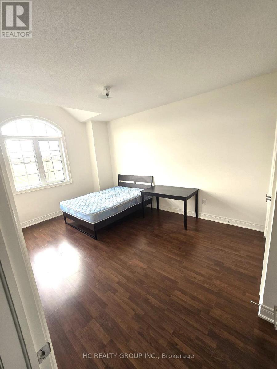 A bedroom with a bed, table and a window.