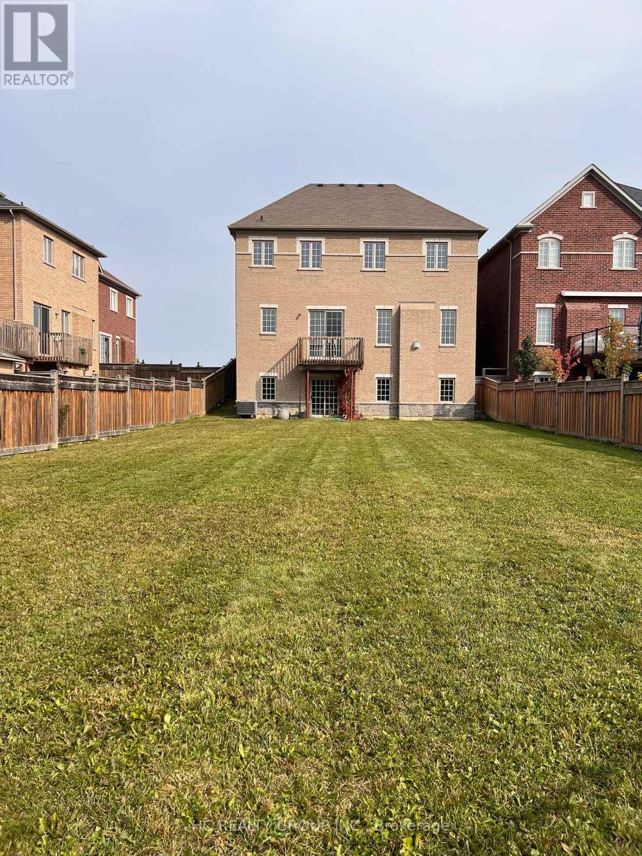 A large grassy yard with a house in the background.