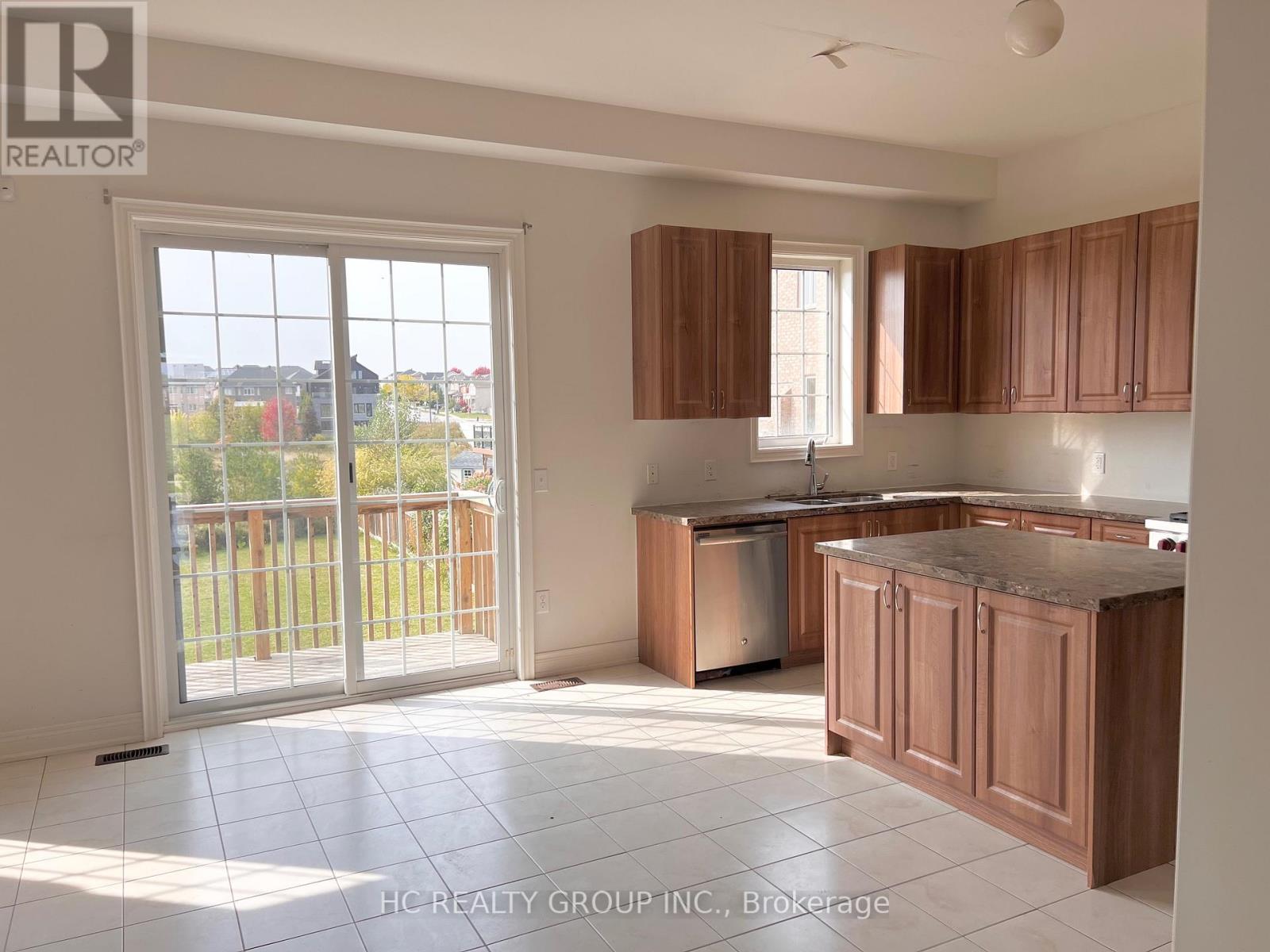 A kitchen with wooden cabinets and a marble countertop.