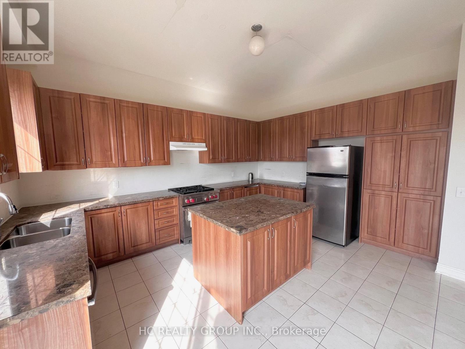 A kitchen with wooden cabinets and a granite countertop.