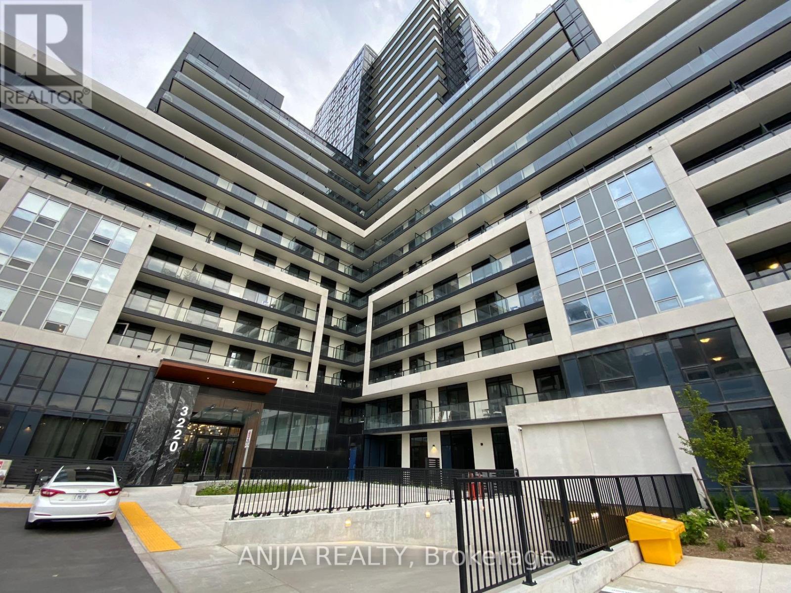 A modern building with a glass facade and a car parked in front.