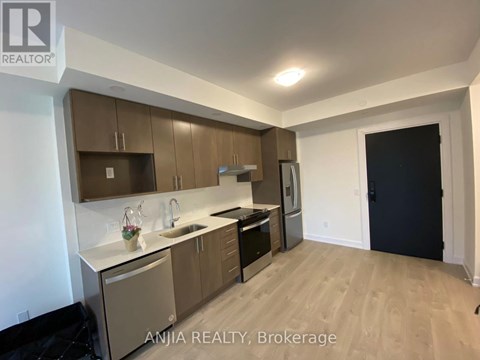 A modern kitchen with wooden cabinets and stainless steel appliances.