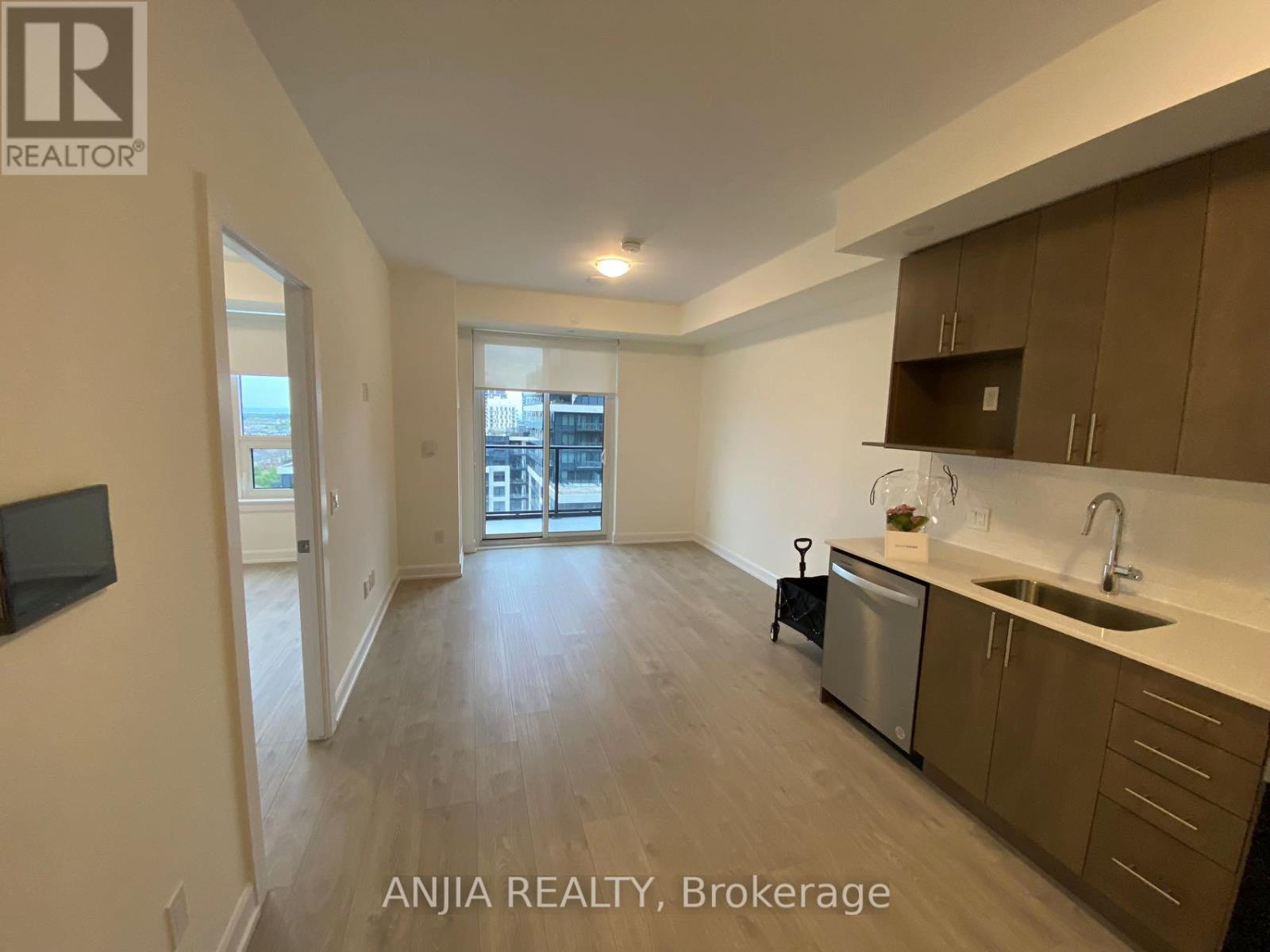 A spacious kitchen with a sink, stove, and cabinets.