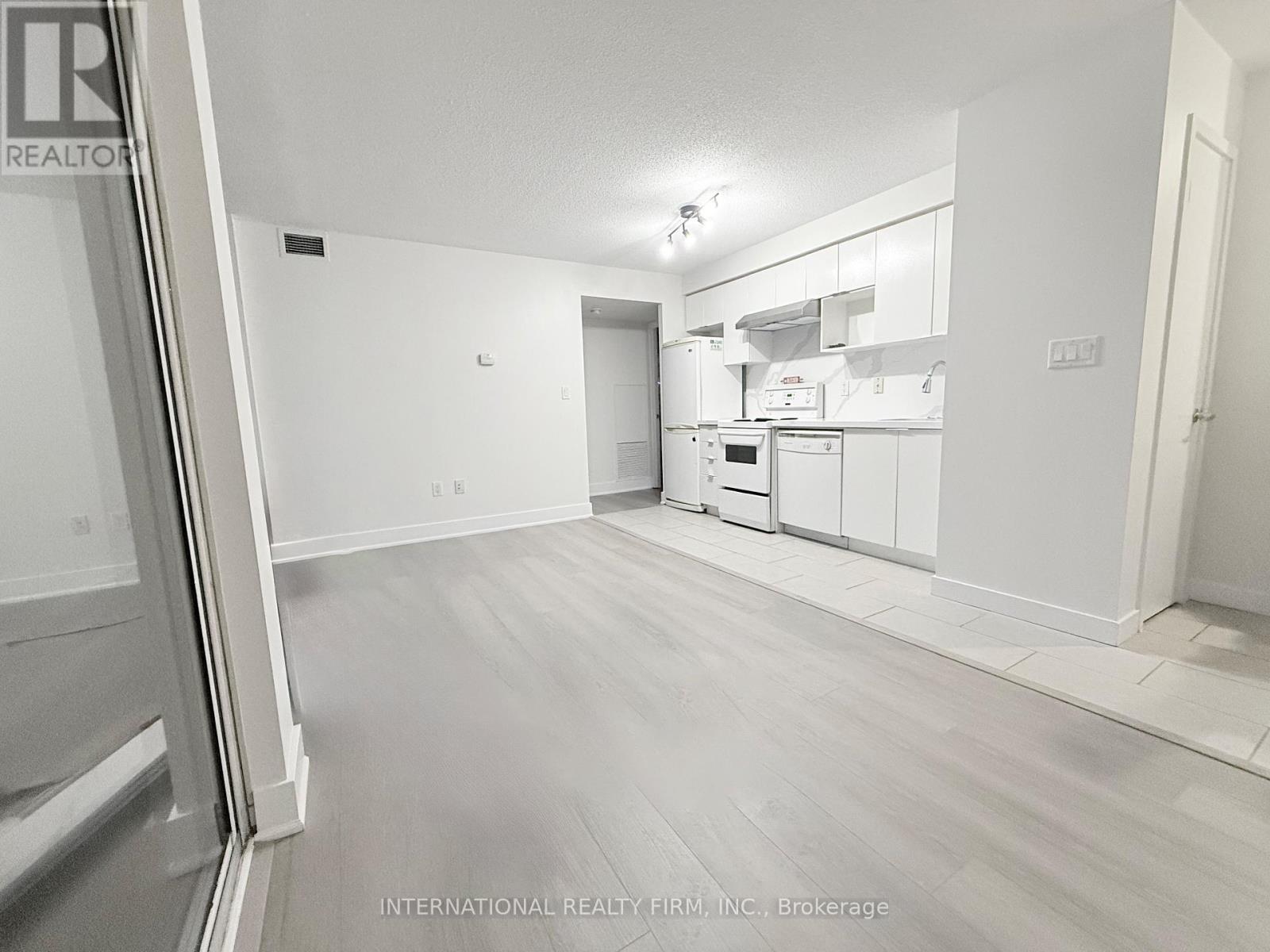 A spacious kitchen with white cabinets and appliances.