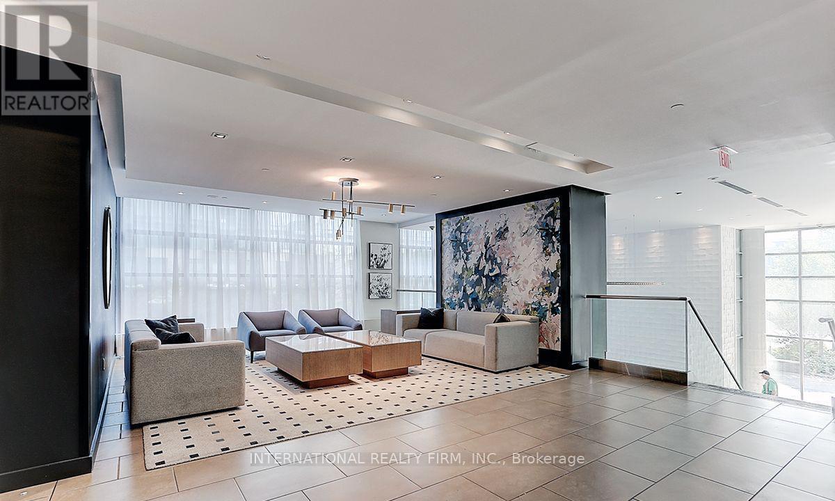 A spacious living room with a large rug and a sofa.