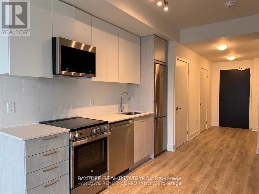 A modern kitchen with a stainless steel oven and microwave.