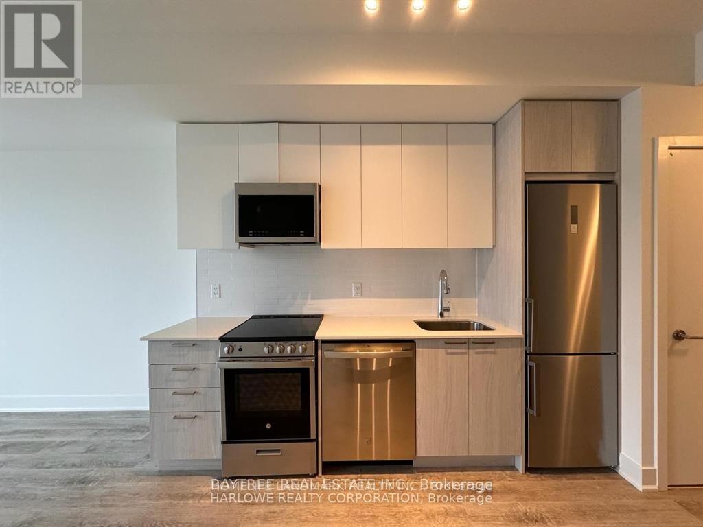 A modern kitchen with stainless steel appliances and white cabinets.