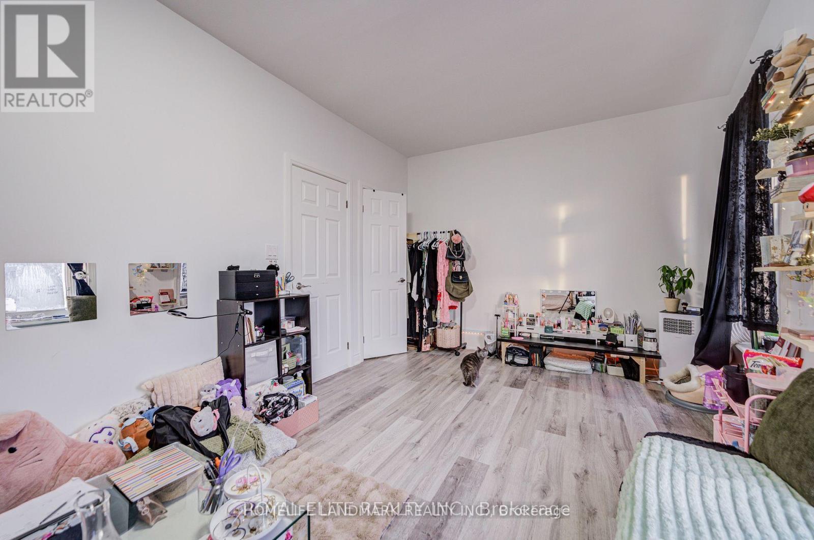 A room with a lot of stuff on the floor and a bed.