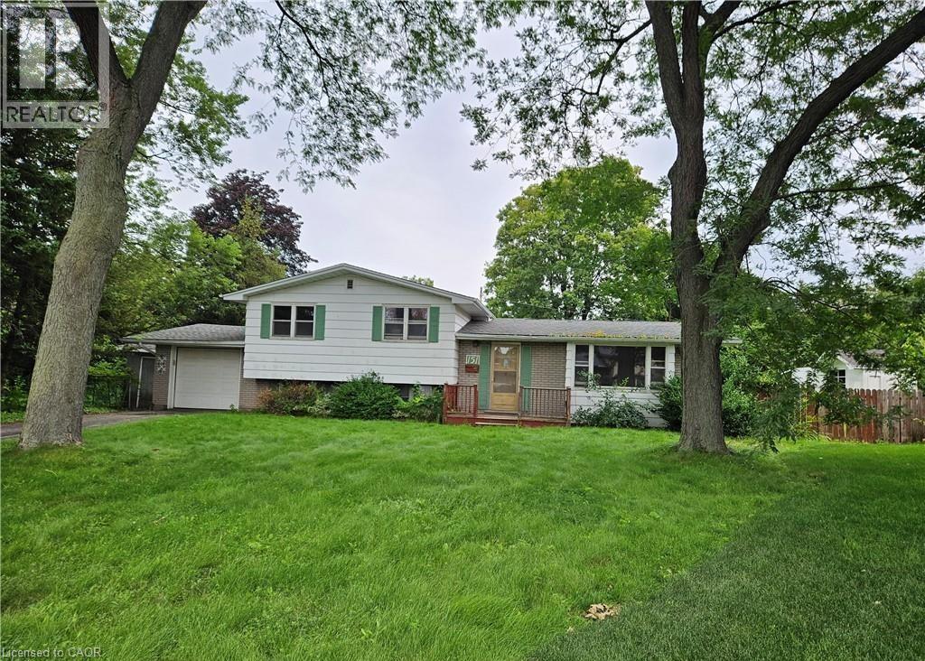 A house with a green lawn and trees in front.