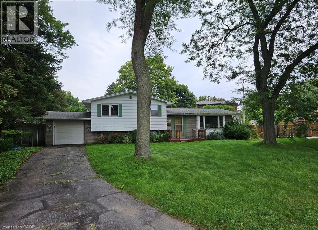 A house with a driveway and a tree in front of it.
