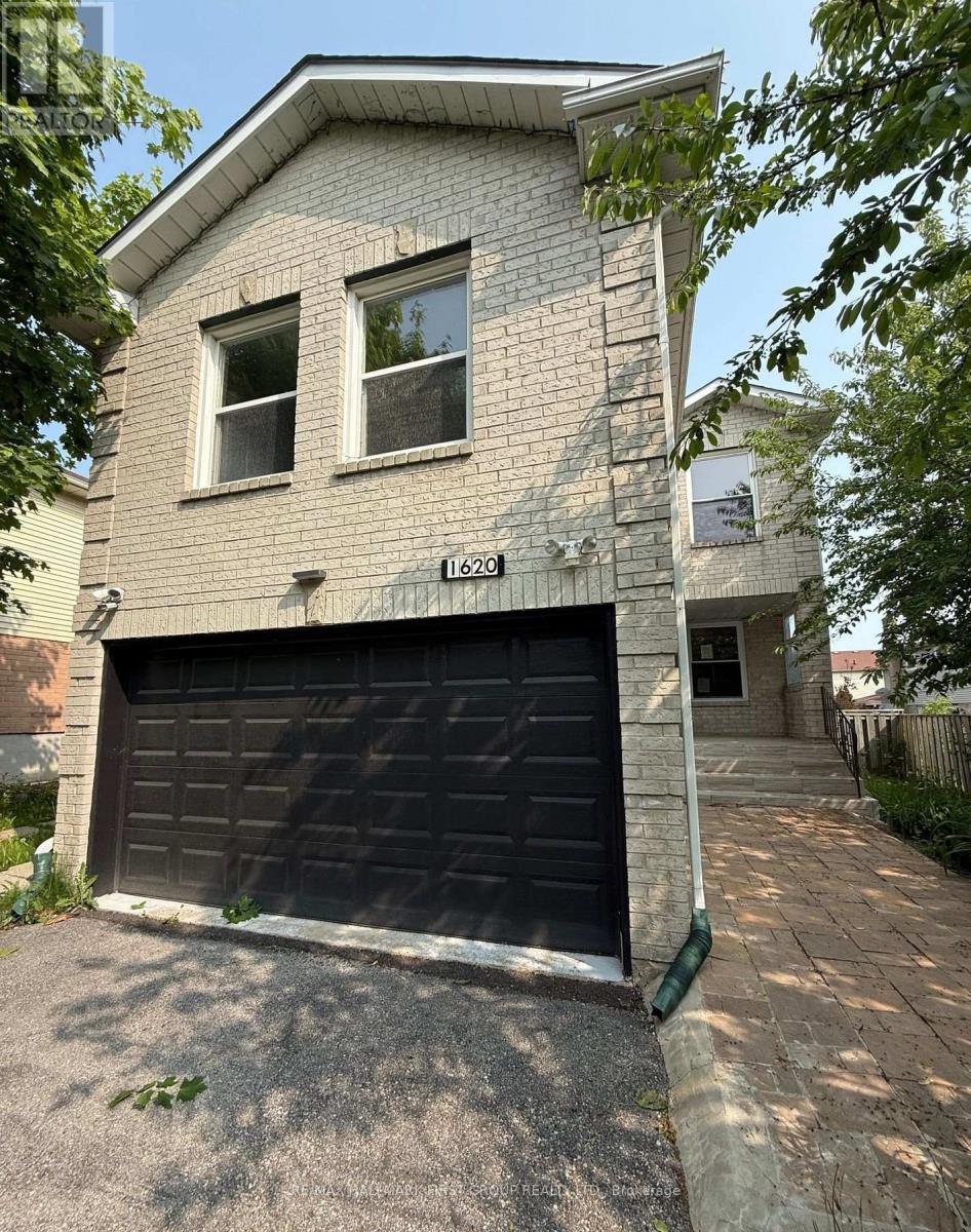 A two-story house with a garage door and a driveway.