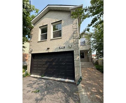 A two-story house with a garage door and a driveway.
