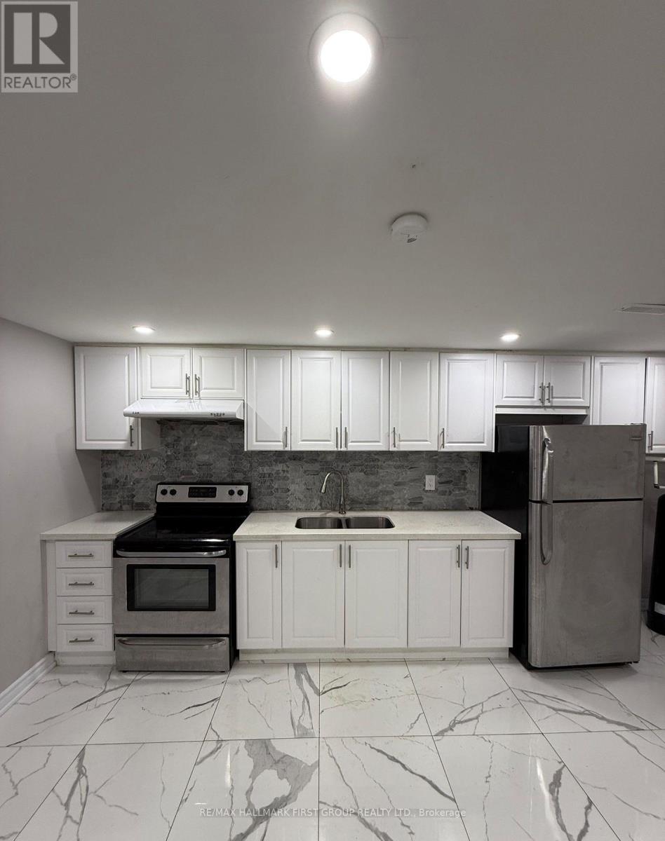 A kitchen with white cabinets and marble flooring.