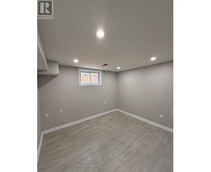 A room with a window and wooden flooring.