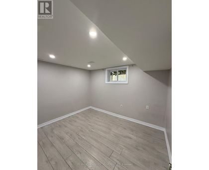 A room with a window and wooden flooring.