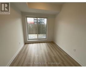 A room with wooden flooring and a glass door leading outside.
