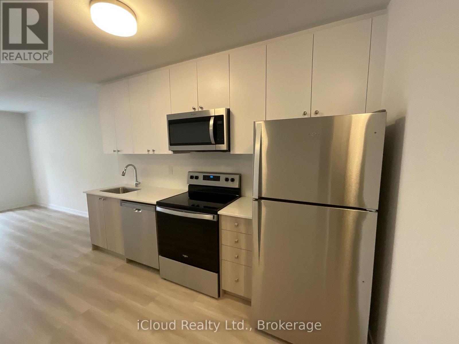 A kitchen with stainless steel appliances and white cabinets.