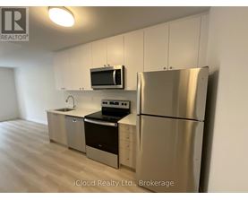 A kitchen with stainless steel appliances and white cabinets.