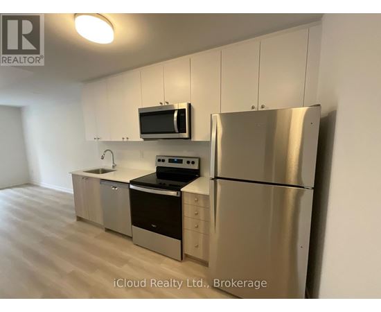 A kitchen with stainless steel appliances and white cabinets.