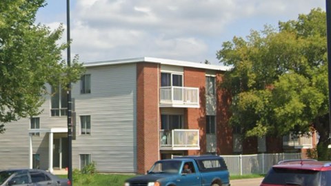 A blue car is parked in front of a building.