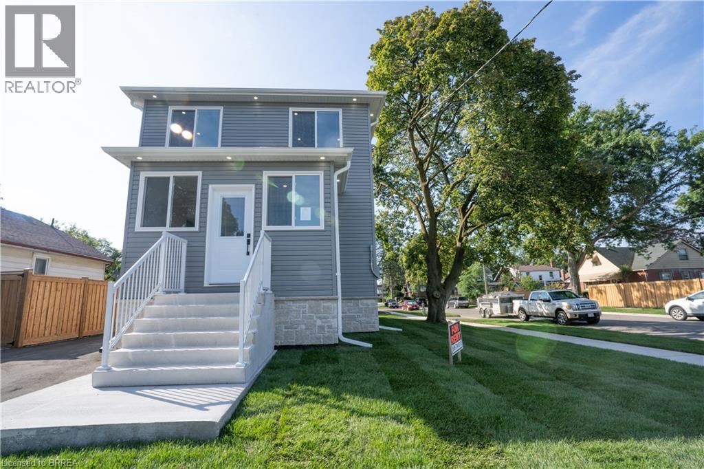 A house with a grey exterior and a white door is for sale.