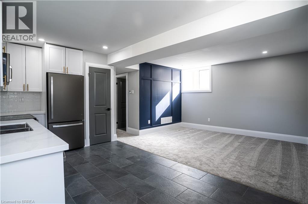 A modern kitchen with a refrigerator, sink, and cabinets.