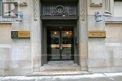The image shows a building entrance with a dark door and a sign above it.