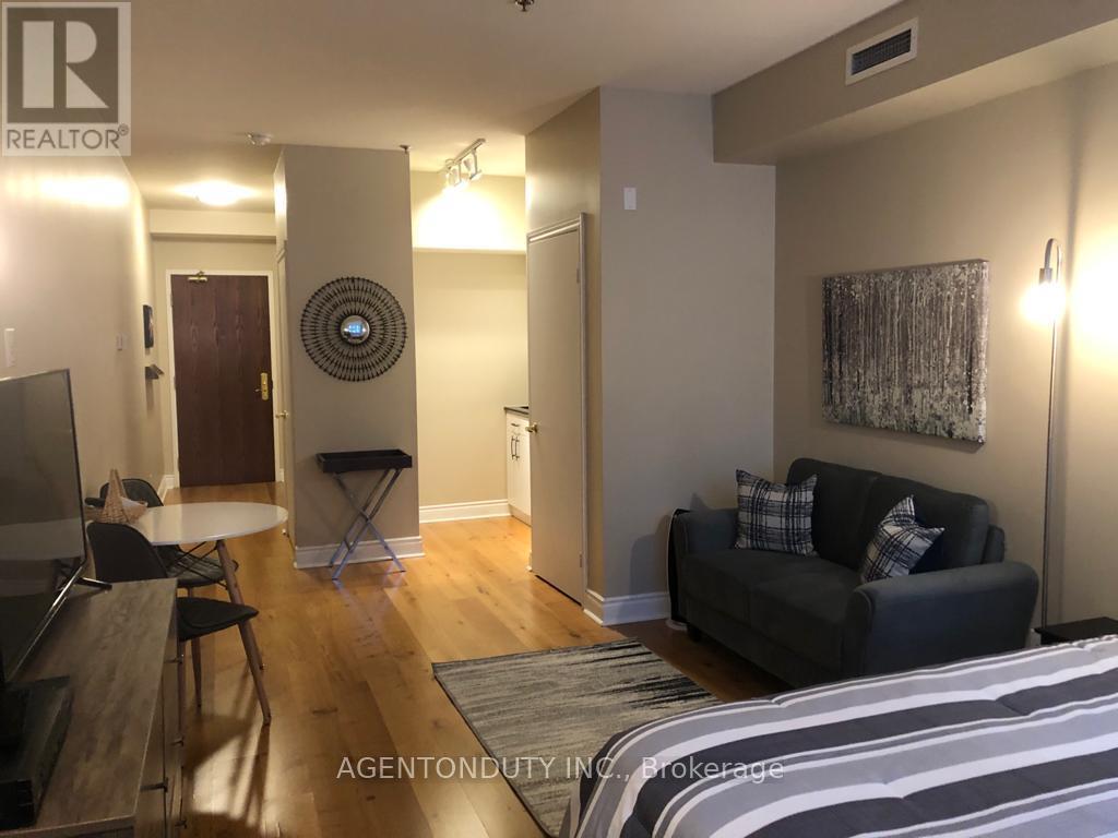 A living room with a couch, a chair, and a television.