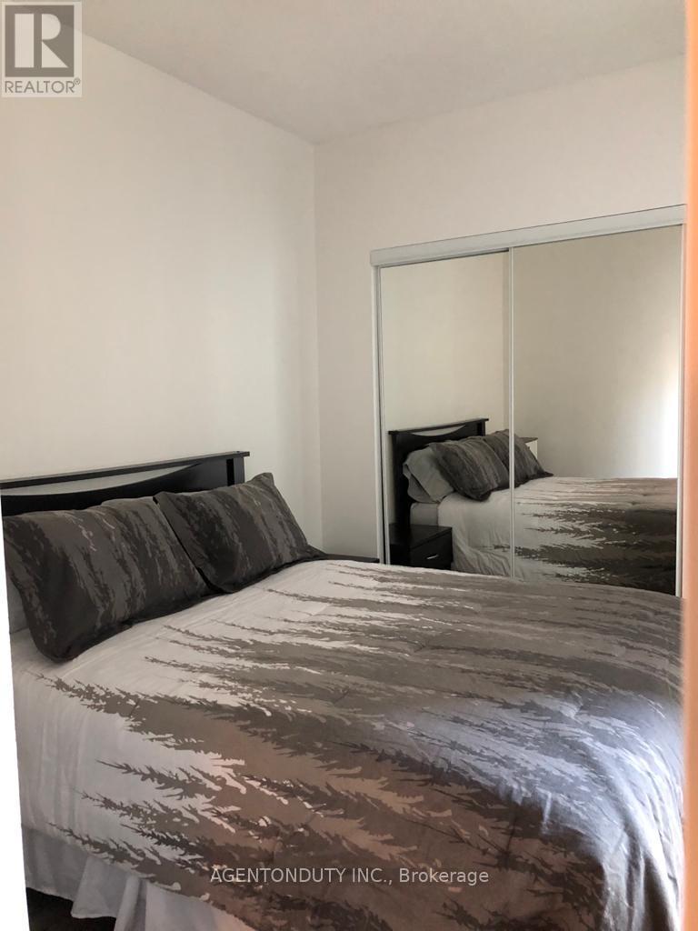 A bedroom with a bed and a mirror on the wall.