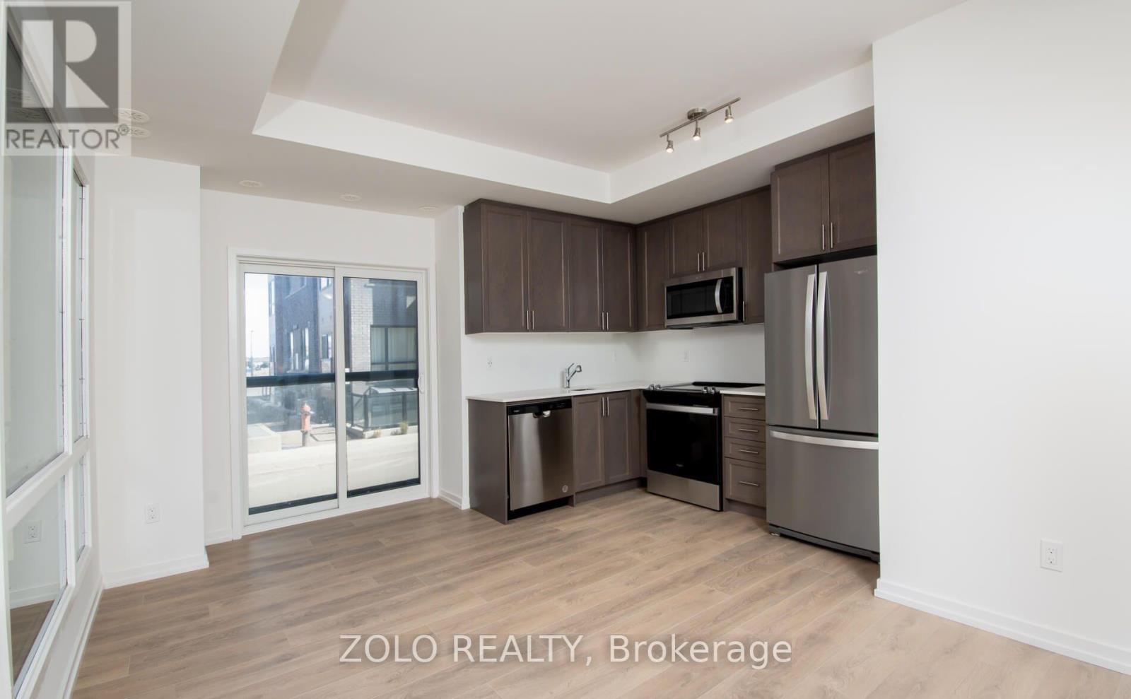 A kitchen with brown cabinets and stainless steel appliances.