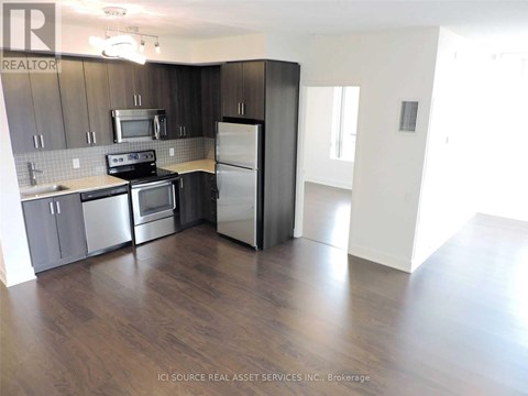 A kitchen with dark wood cabinets and stainless steel appliances.