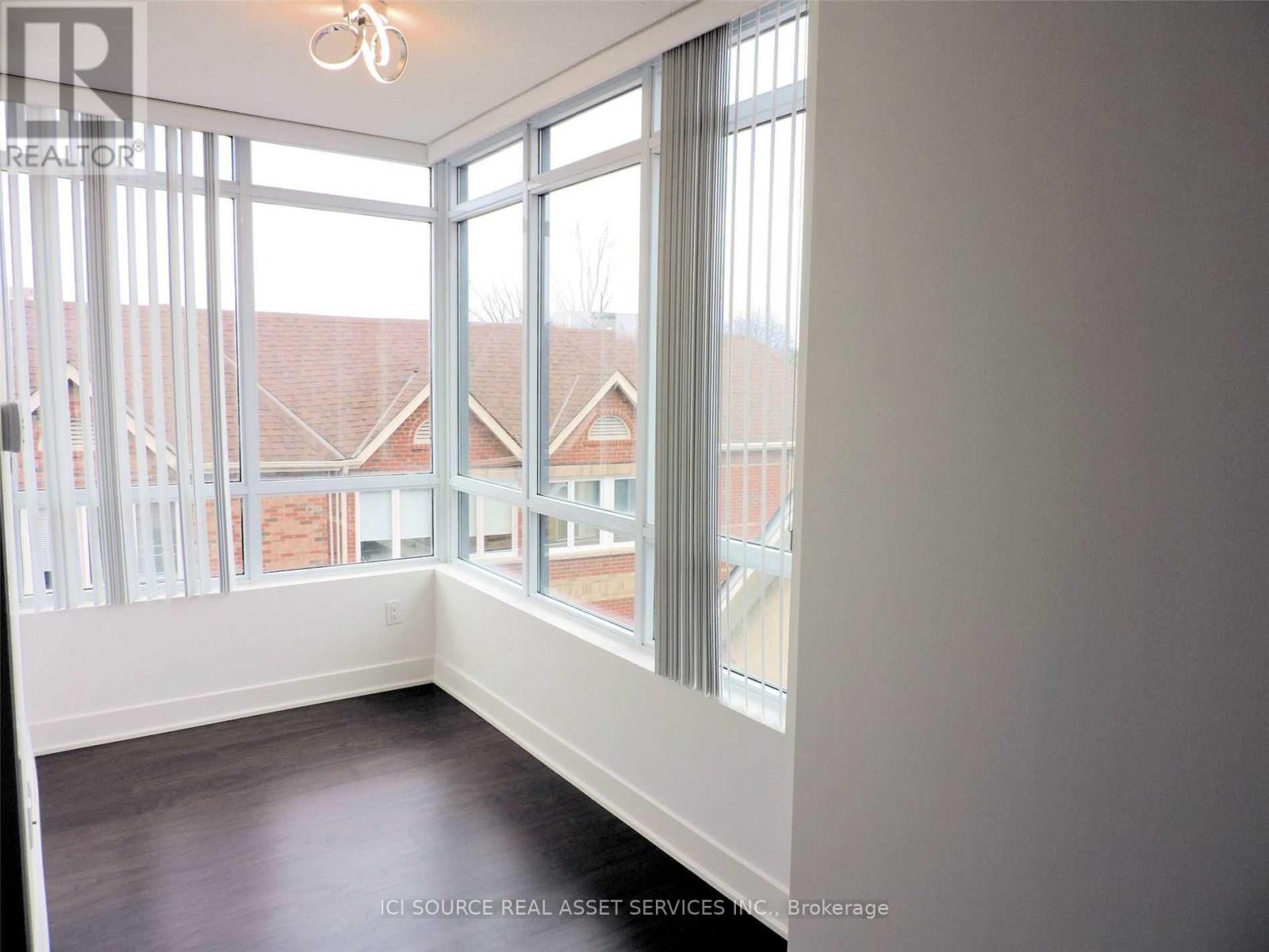 A room with a large window and a view of a building outside.