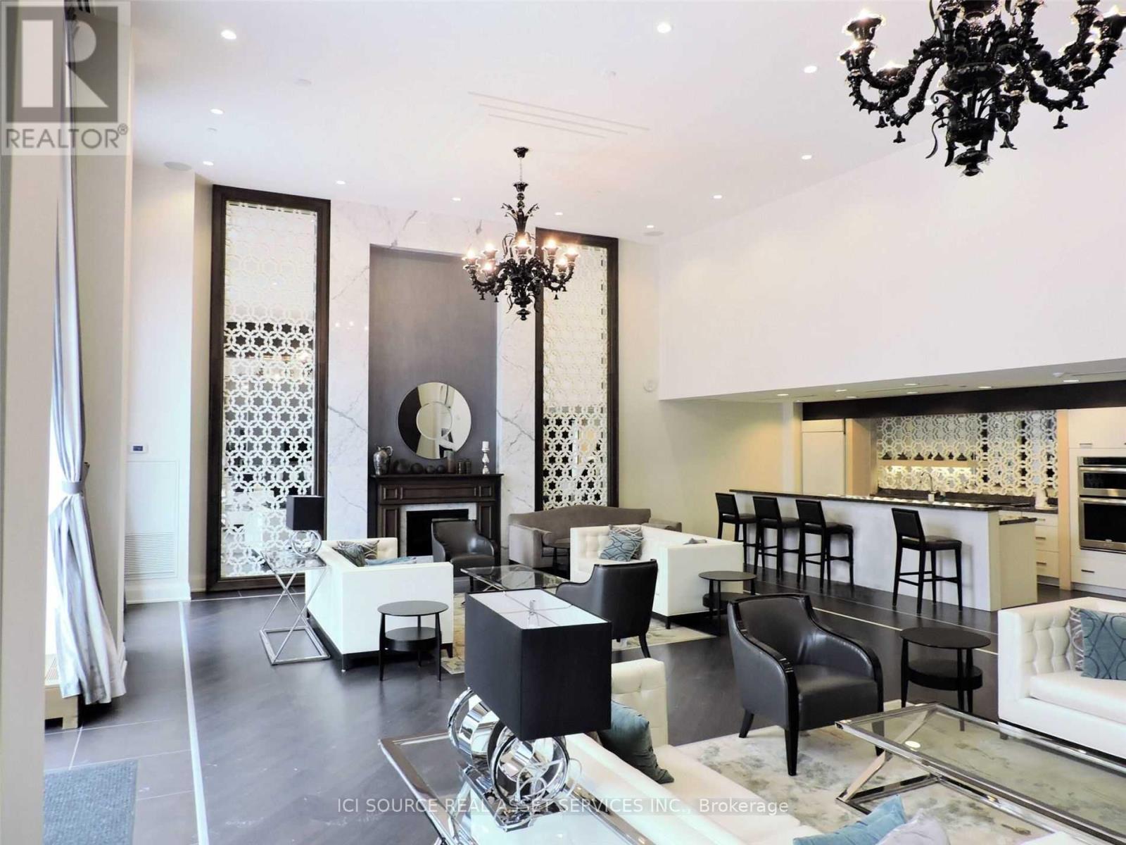 A living room with a chandelier, a fireplace, and a dining table.