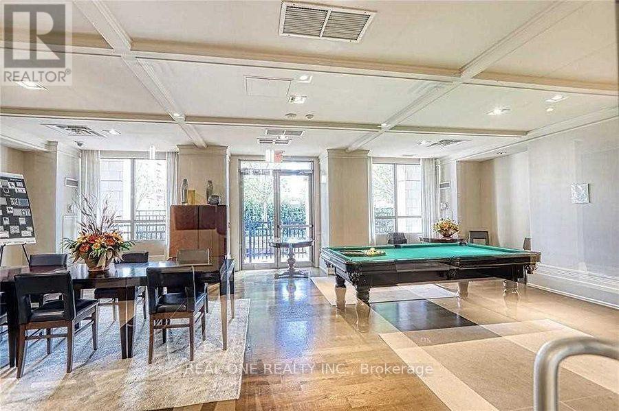 A well-lit room with a pool table and a dining table.