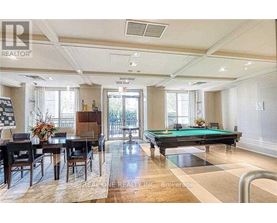 A well-lit room with a pool table and a dining table.
