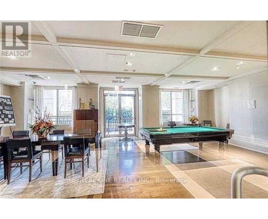 A well-lit room with a pool table and a dining table.