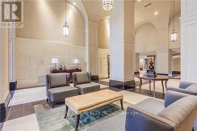 A spacious living room with a large couch, a coffee table, and a dining table set up.