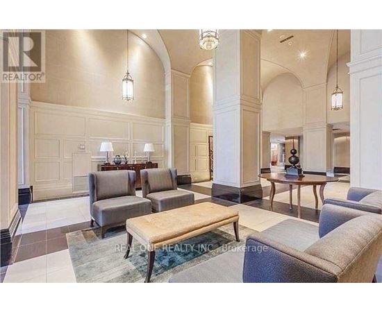 A spacious living room with a large couch, a coffee table, and a dining table set up.
