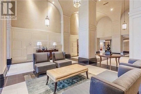 A spacious living room with a large couch, a coffee table, and a dining table set up.