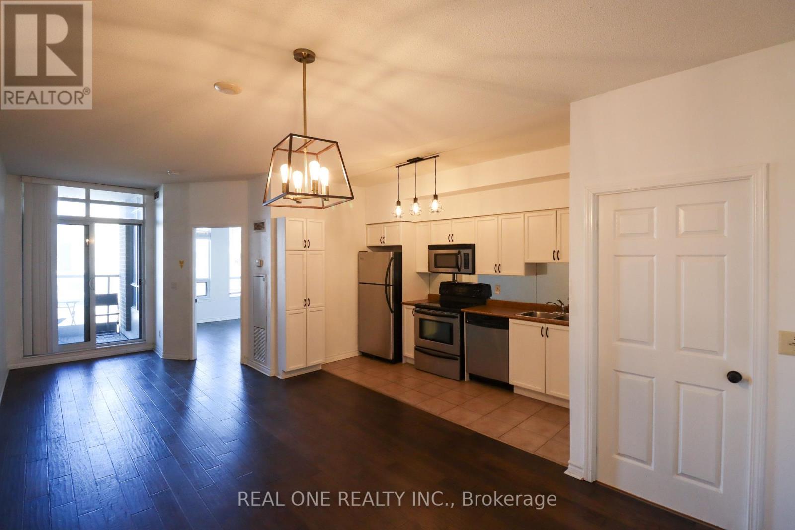 A well-lit kitchen with white cabinets and a black stove top oven.