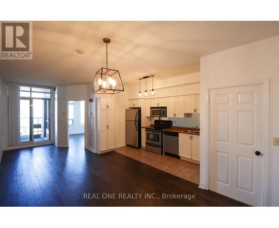 A well-lit kitchen with white cabinets and a black stove top oven.