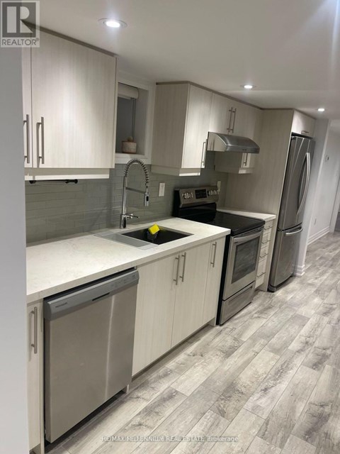 A modern kitchen with white cabinets and a grey floor.