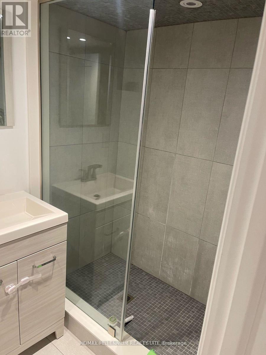 A bathroom with a glass shower door and a white sink.