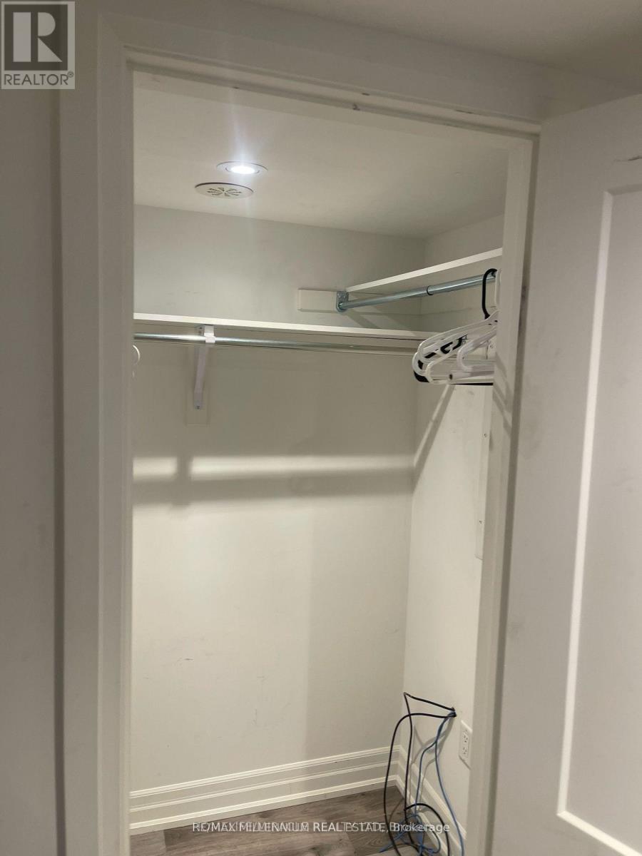 A white closet with a hanger and a hook on the wall.