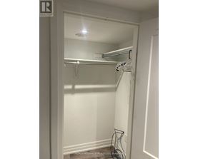 A white closet with a hanger and a hook on the wall.