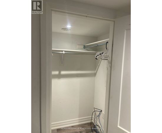 A white closet with a hanger and a hook on the wall.
