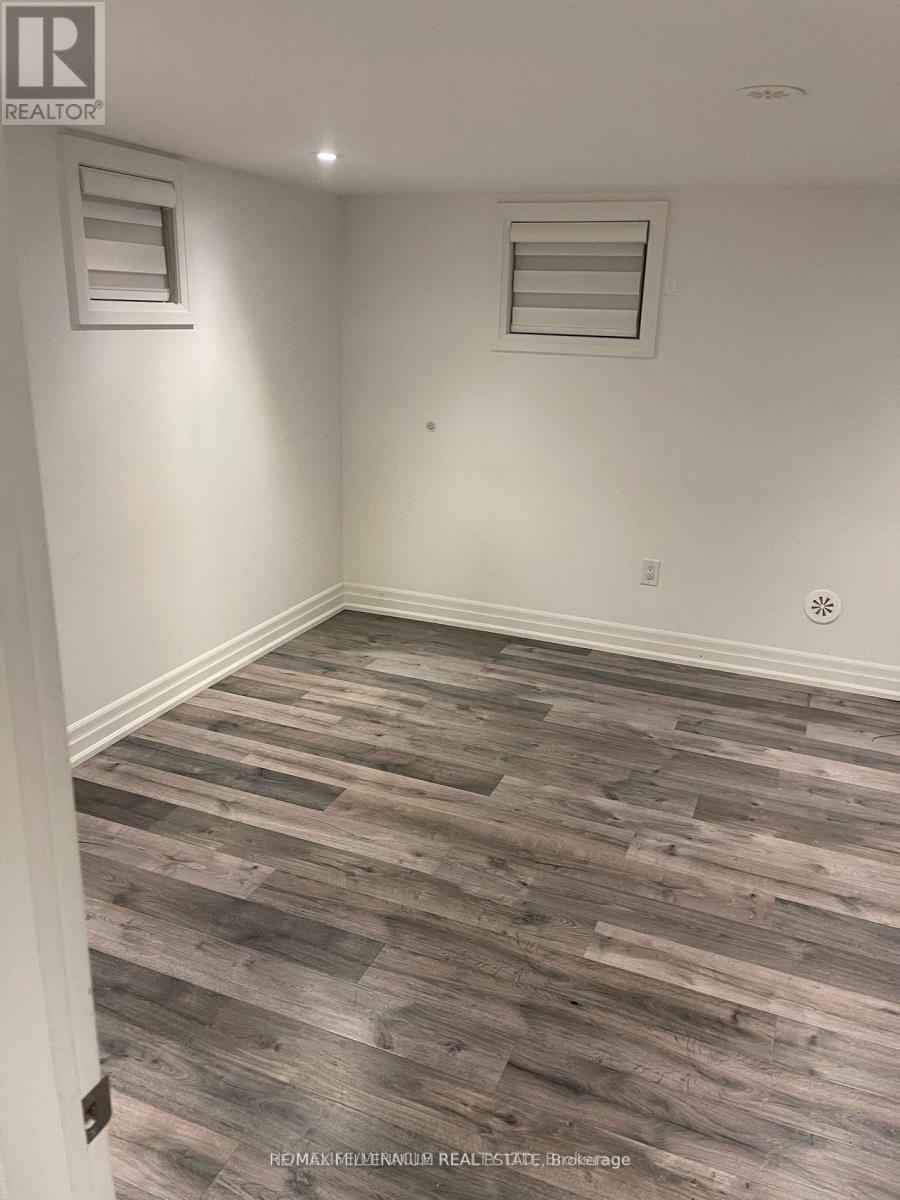 A room with wooden flooring and white walls.