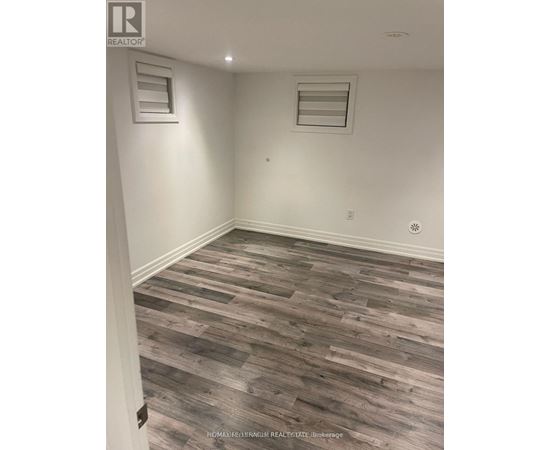 A room with wooden flooring and white walls.